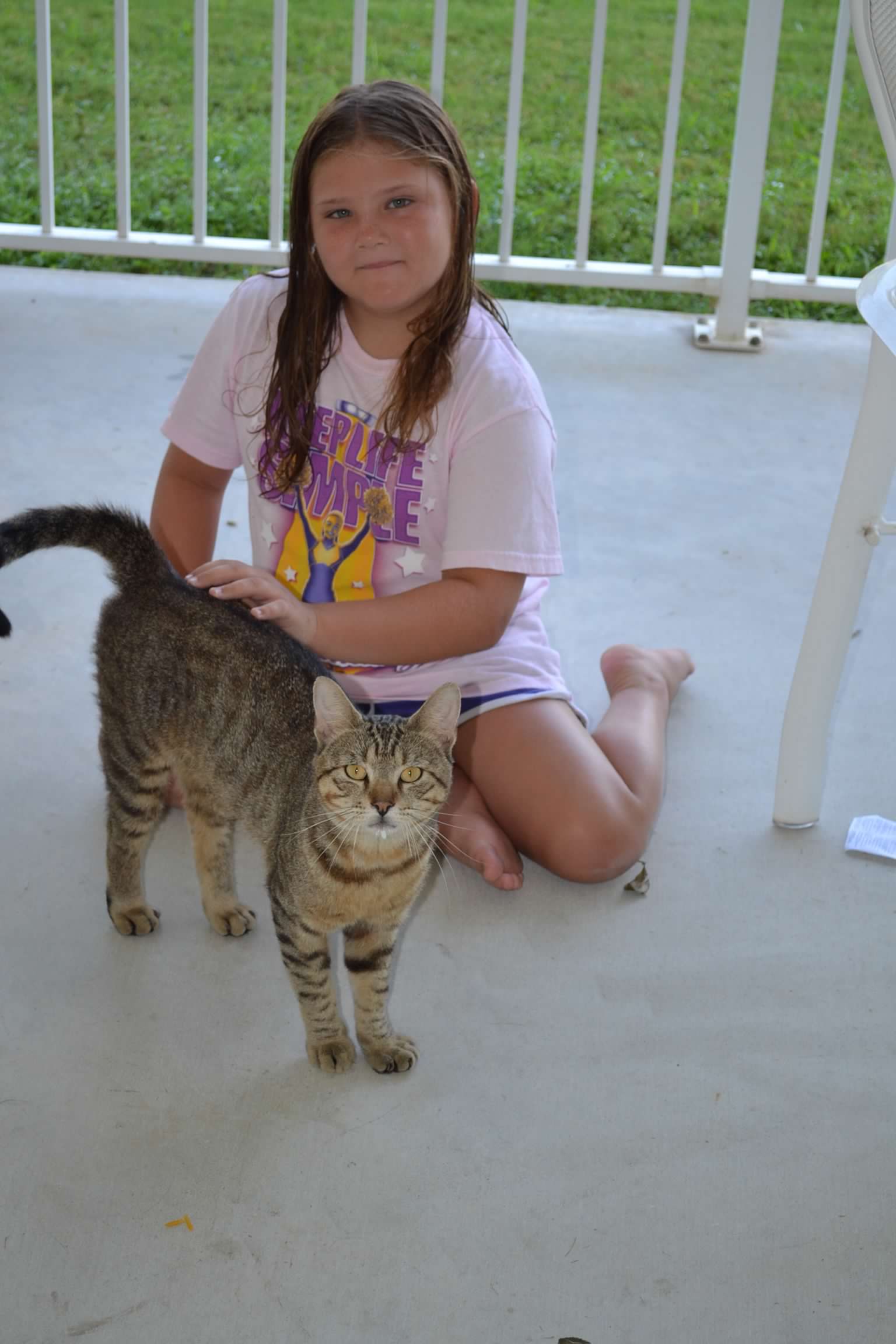 Bailey Schmitt sitting on a porch with the family cat