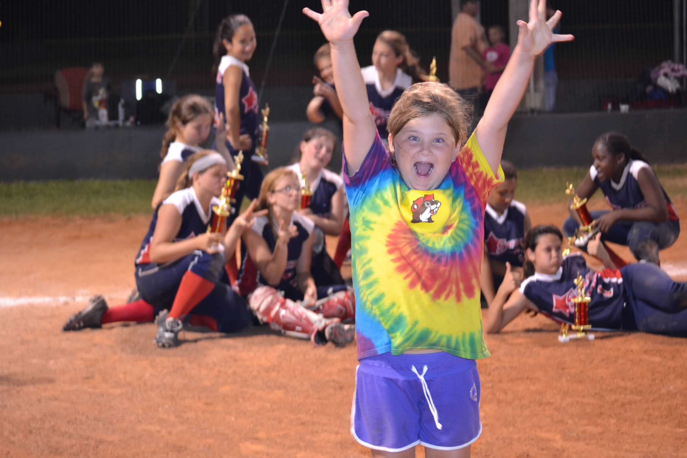 Bailey Schmitt cheering on the softball field with her team behind her