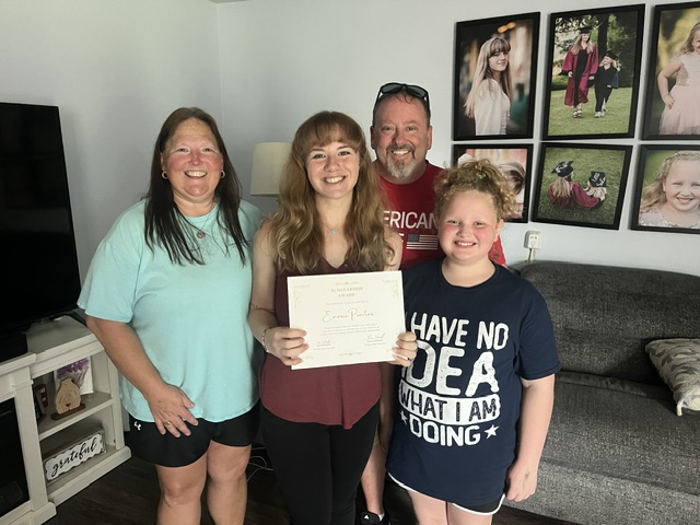 Emorie Proctor, 2026 Bailey Schmitt Memorial Fund scholarship recipient, holding her certificate at home with family